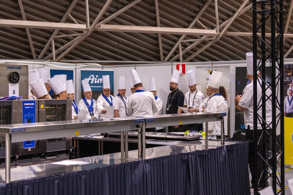 Taitaja2022 kokkituomarit valmiina aloittamaan arviointityönsä, keskellä Fredmanin keittiömestari Ville Parkkinen.